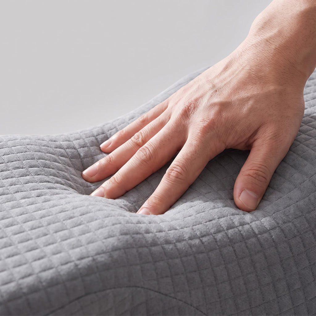 A hand pressing into the Wova Rest pillow foam, gray